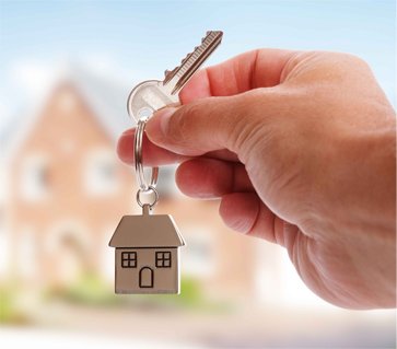 Mão segurando a chave de uma casa recém-adquirida